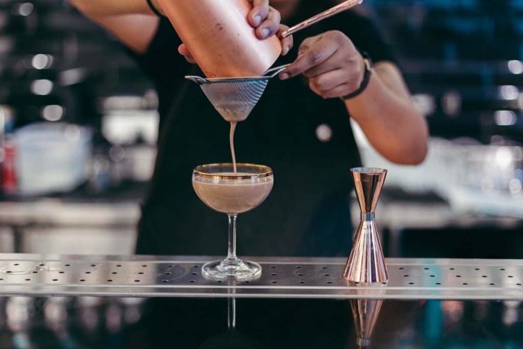 bartender pouring a craft cocktail